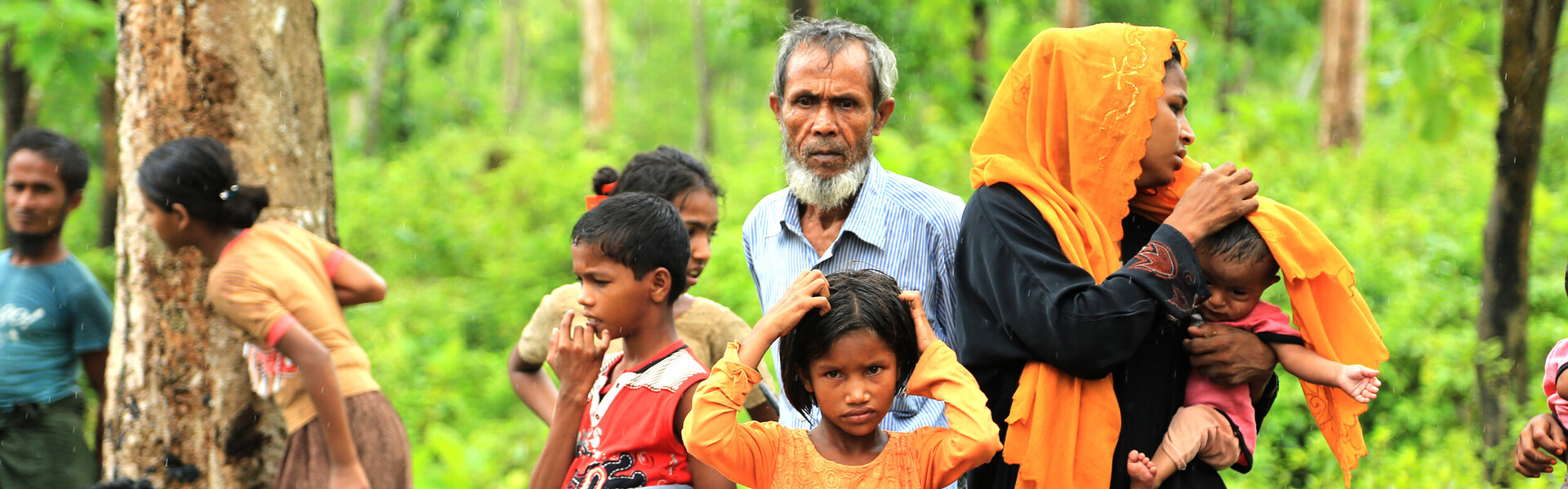 In Bangladesh stehen Frauen und Männer mit Kindern.