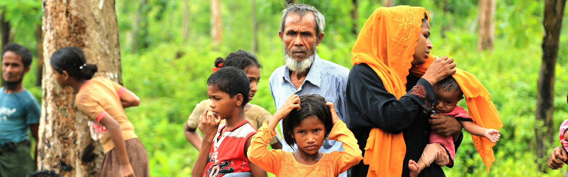In Bangladesh stehen Frauen und Männer mit Kindern.