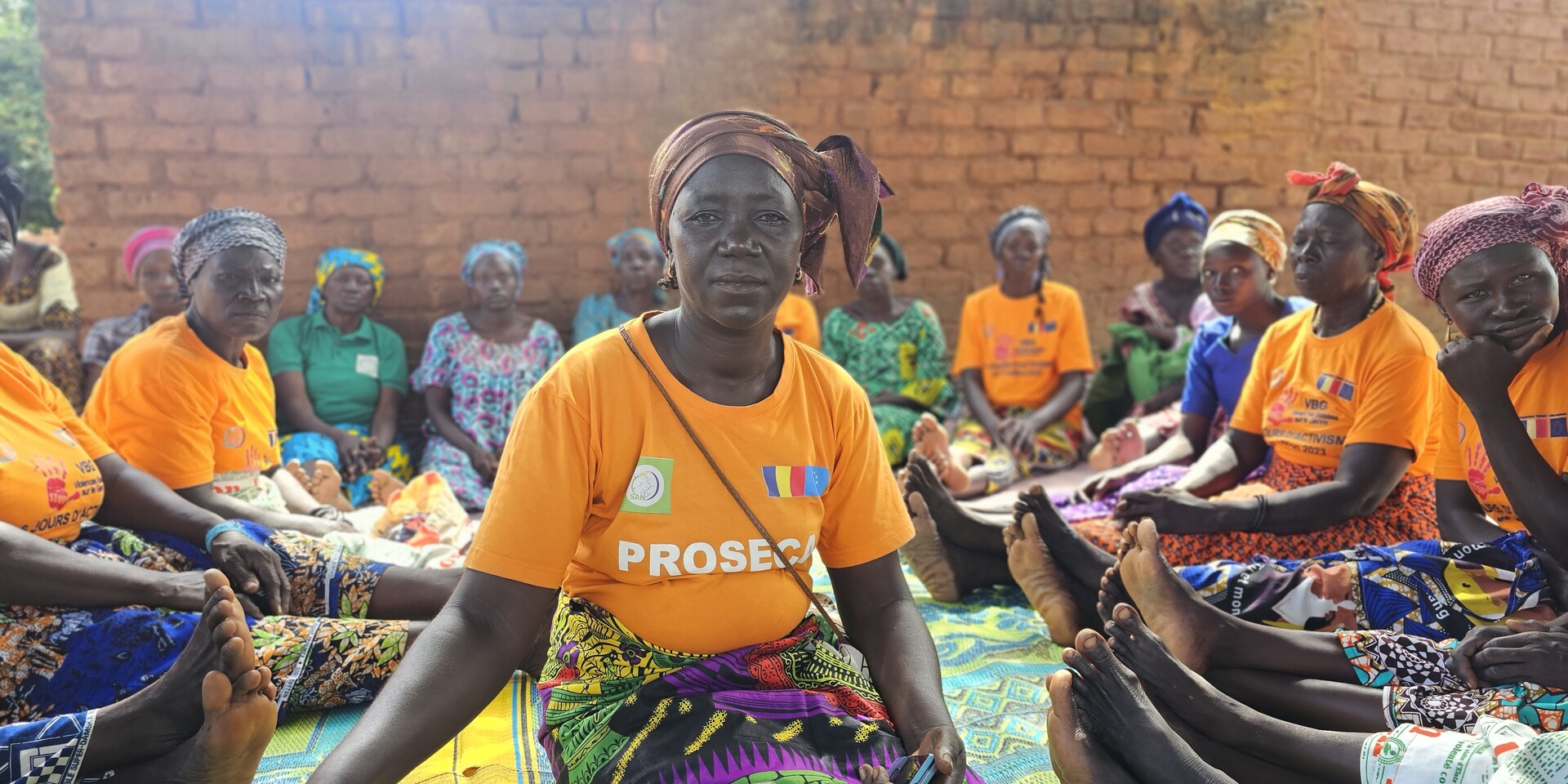 Rachel sitzt gemeinsam mit anderen Frauen aus ihrer Spargruppe auf einer Decke auf dem Boden