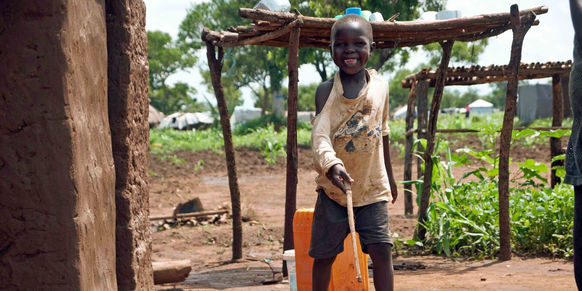 Ein Junge in einem Flüchtlingscamp in Uganda mit seinem selbst gebastelten Spielzeug Ein Junge in einem Flüchtlingscamp in Uganda mit seinem selbst gebastelten Spielzeug