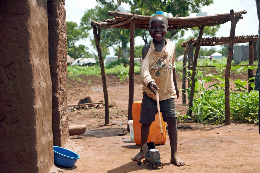 Ein Junge in einem Flüchtlingscamp in Uganda mit seinem selbst gebastelten Spielzeug