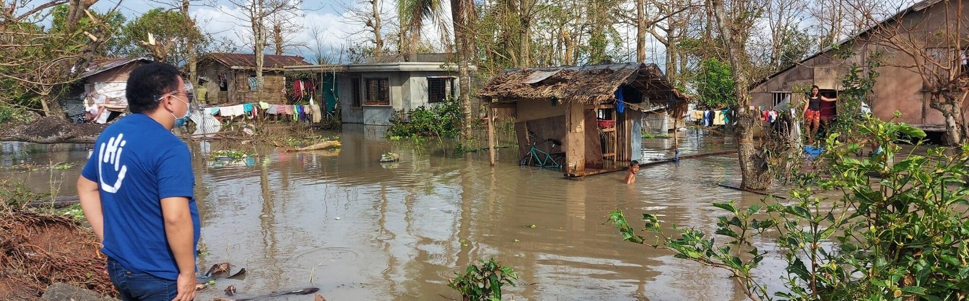 Ein Helfer vor zerstörten Häusern nach einem Taifun auf den Philippinen
