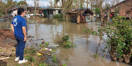 Ein Helfer vor zerstörten Häusern nach einem Taifun auf den Philippinen