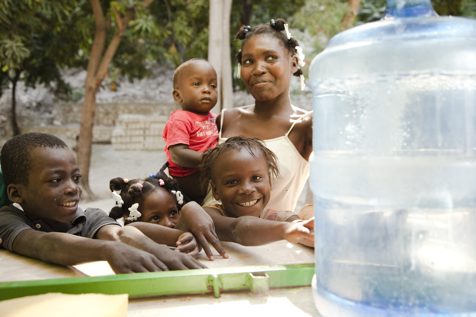 Familien erhalten frisches Trinkwasser von der Hilfsorganisation action medeor nach dem Erdbeben auf Haiti
