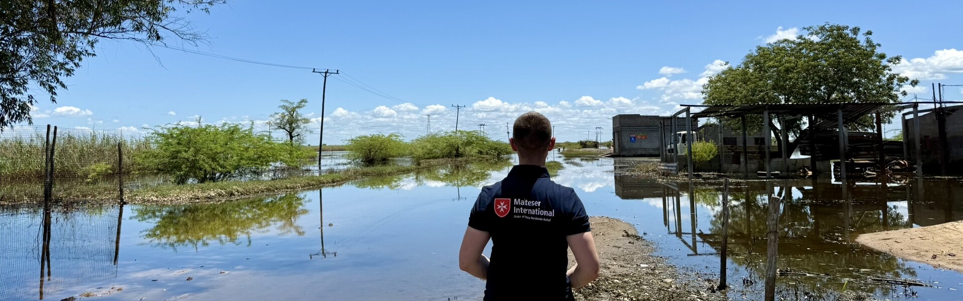 Helfer der Malteser International steht in Mosambik und blickt auf überschwemmtes Land