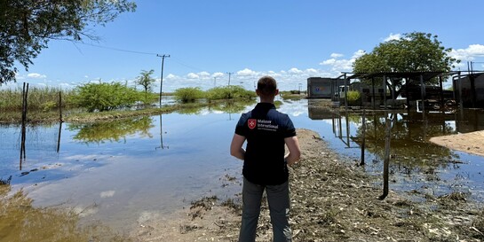 Helfer der Malteser International steht in Mosambik und blickt auf überschwemmtes Land