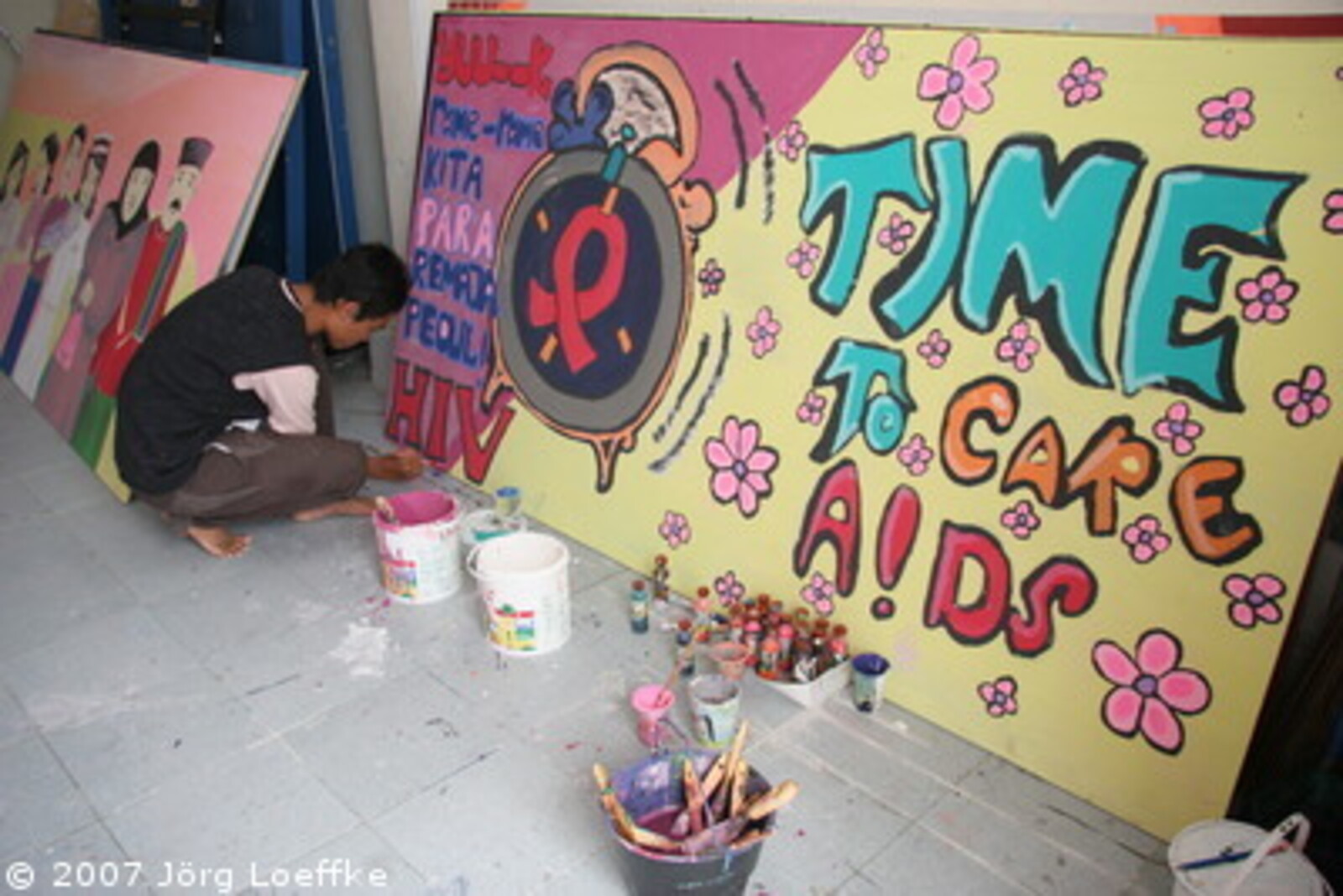 Tsunami-Hilfe Indonesien: ein Jugendlicher aus den CARE-Projekt malt ein Aidsplakat