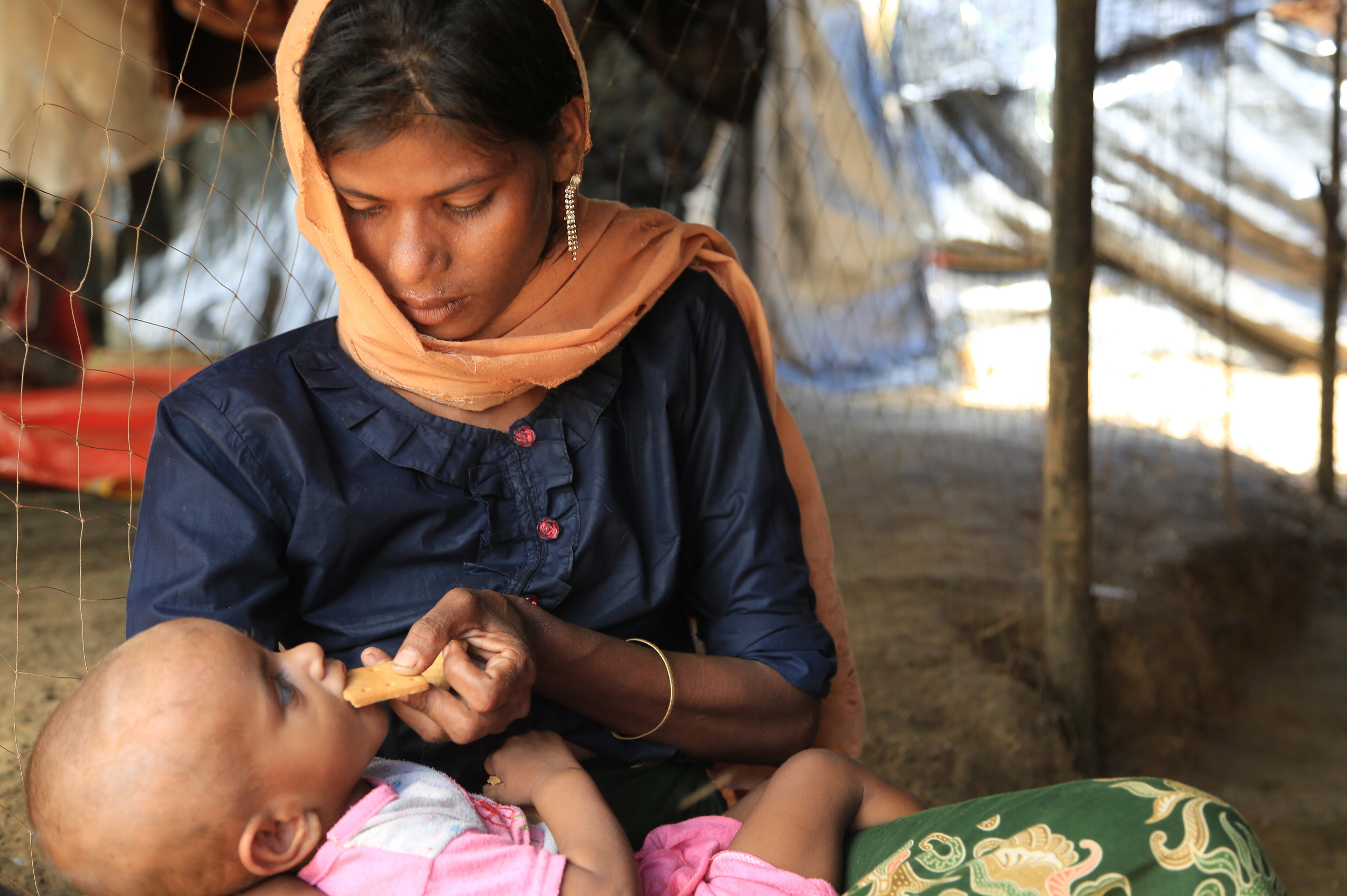 Eine Frau füttert ihr Baby in einem Flüchtlingscamp für Rohingya in Bangladesch Eine Frau füttert ihr Baby in einem Flüchtlingscamp für Rohingya in Bangladesch