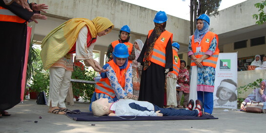 In Pakistan lernen Teilnehmer in einem Erste-Hilfe-Kurs die richtige Herzmassage an einer Puppe
