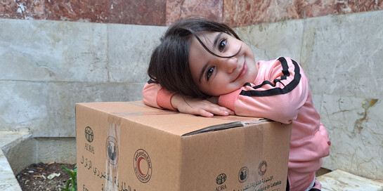 Ein Kind in Syrien freut sich über Hilfspaket