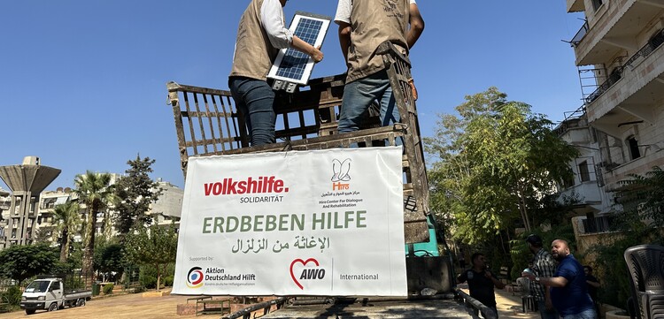 Helfer der Organisation AWO International unterstützen beim Wiederaufbau und montieren Solarlampen Helfer der Organisation AWO International unterstützen beim Wiederaufbau und montieren Solarlampen