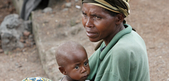 Mutter sitzt mit einem Kind auf dem Boden in der Demokratischen Republik Kongo während der Hungerkatastrophe in Afrika.