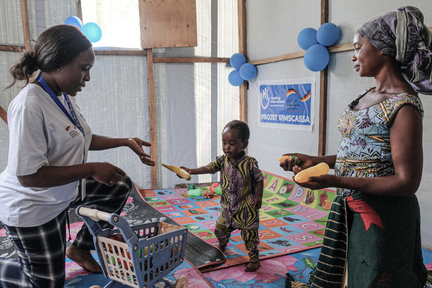 Ein Kleinkind mit seiner Mutter und einer Helferin bei der Spieltherapie