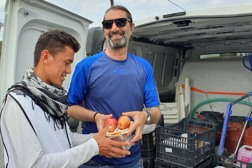 Zwei Männer bei der Verteilung von Hilfsgütern