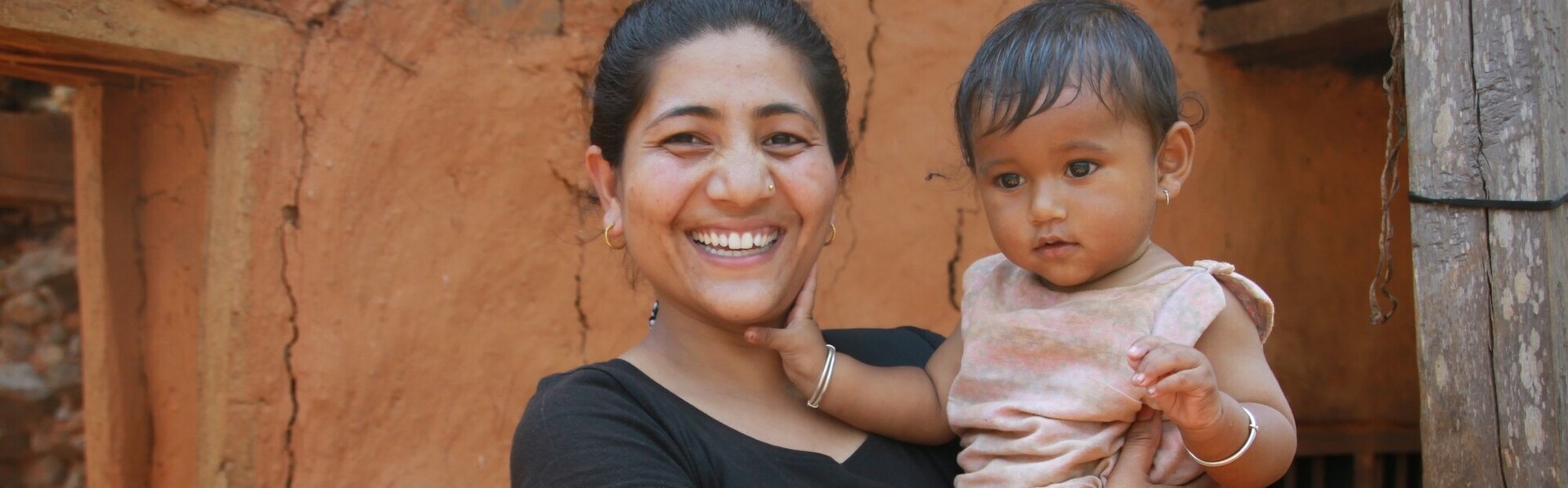 Eine Mutter in Nepal hält ihre Tochter auf dem Arm