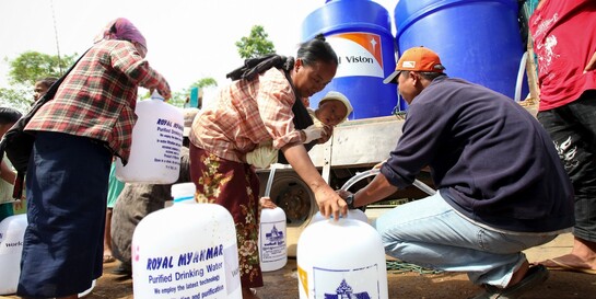 Personen und mit Trinkwasser gefüllt Wassertanks in Myanmar