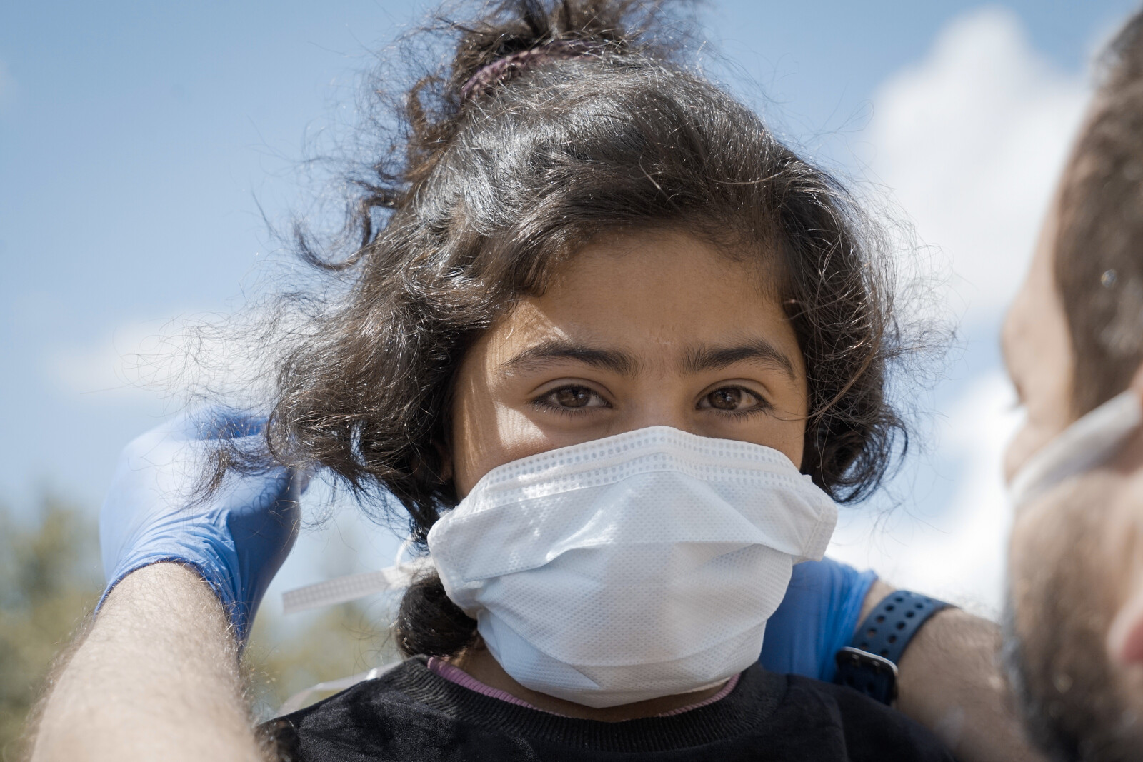 Ein Mädchen in Syrien trägt eine Atemschutzmaske