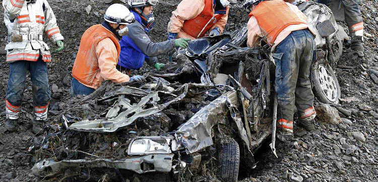 Die Retter suchen in einem Autowrack nach Verschütteten.