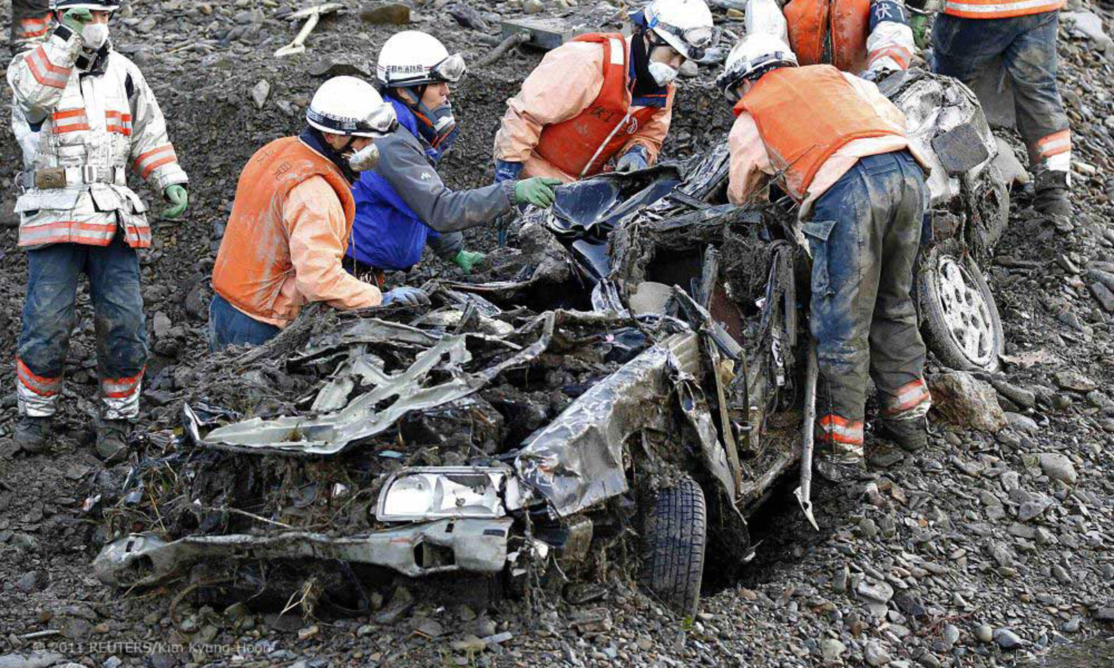 Die Retter suchen in einem Autowrack nach Verschütteten.