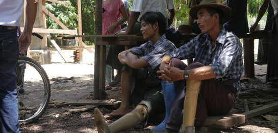 Zwei Opfer von Minen sitzen vor einem Bau in Myanmar. Überschwemmungen haben 2015 Myanmar schwer getroffen.