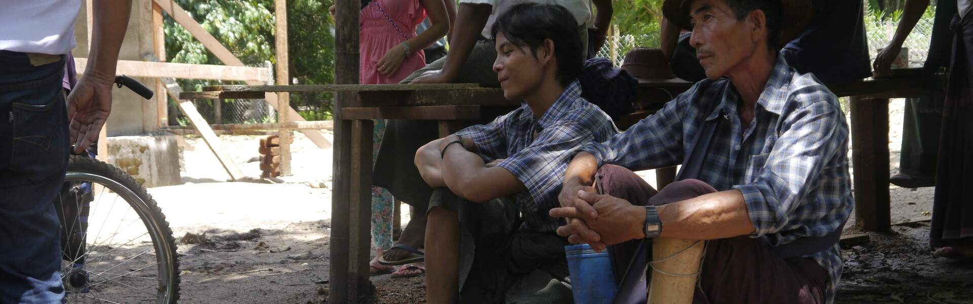 Zwei Opfer von Minen sitzen vor einem Bau in Myanmar. Überschwemmungen haben 2015 Myanmar schwer getroffen.