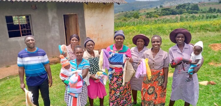 Frauen, Kinder und Männer bei einem Hilfsprojekt in Simbabwe