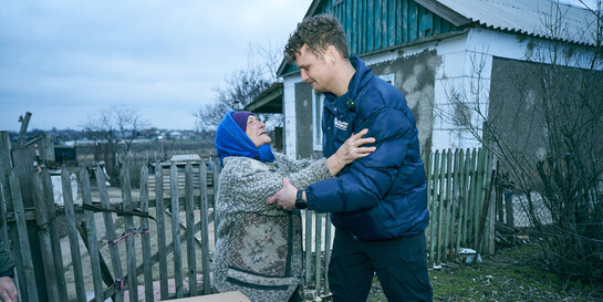 Ein Helfer von action medeor beliefert eine Frau in der Ukraine mit Gasflaschen