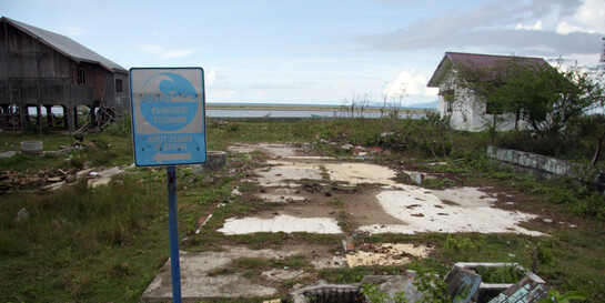 An gefährdeten Küsten werden Schilder aufgestellt, damit die Menschen im Notfall wissen, wohin sie vor einem herannahenden Tsunami fliehen können.