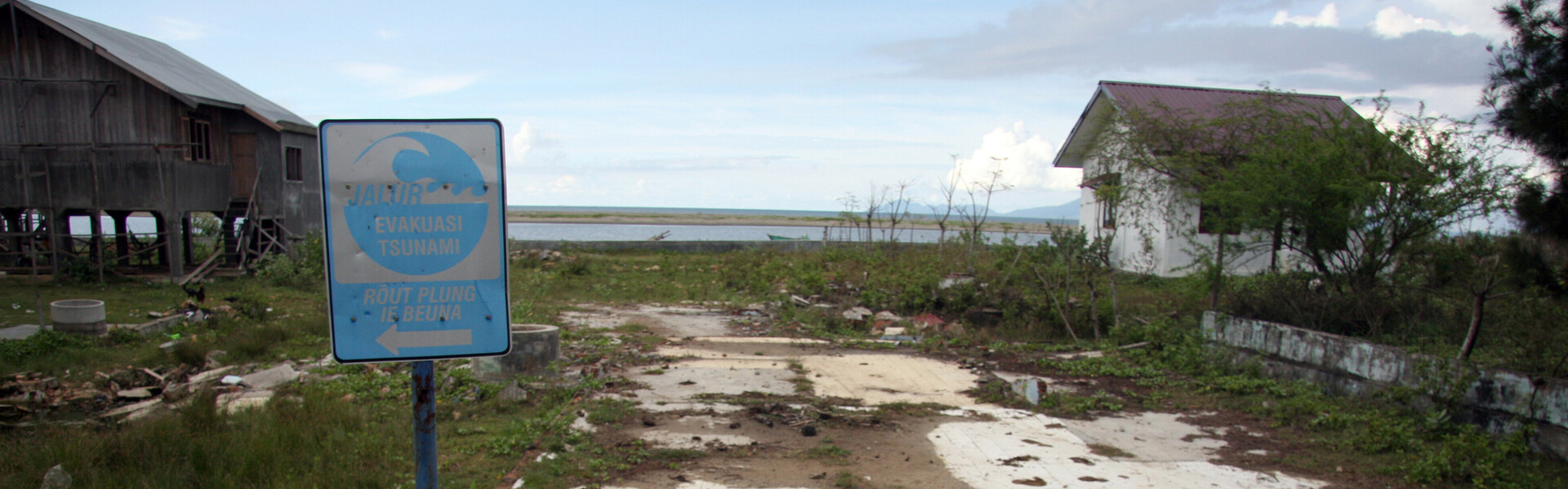 An gefährdeten Küsten werden Schilder aufgestellt, damit die Menschen im Notfall wissen, wohin sie vor einem herannahenden Tsunami fliehen können.