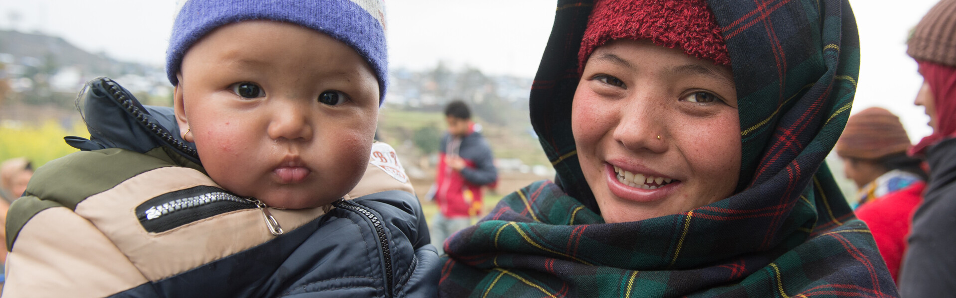 Eine Mutter aus Nepal hält ihr Kind auf dem Arm.