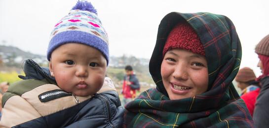 Eine Mutter aus Nepal hält ihr Kind auf dem Arm.