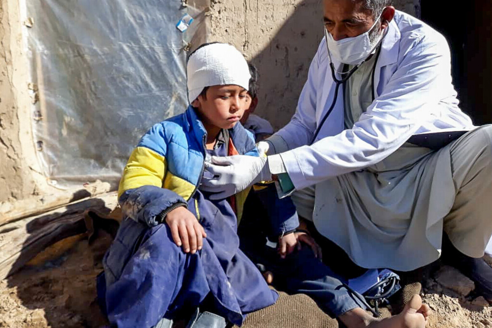 Ein verletztes Kind und ein Arzt in Afghanistan
