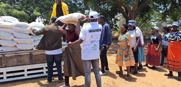Frauen und Männer in Simbabwe entladen eine Hilfslieferung Frauen und Männer in Simbabwe entladen eine Hilfslieferung