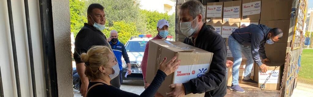 Eine Frau im Libanon nimmt Hilfsgüter von den Johannitern entgegen