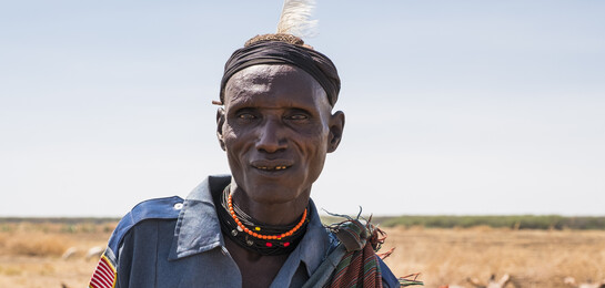 Ein Hirte aus Kenia steht vor seiner Herde.