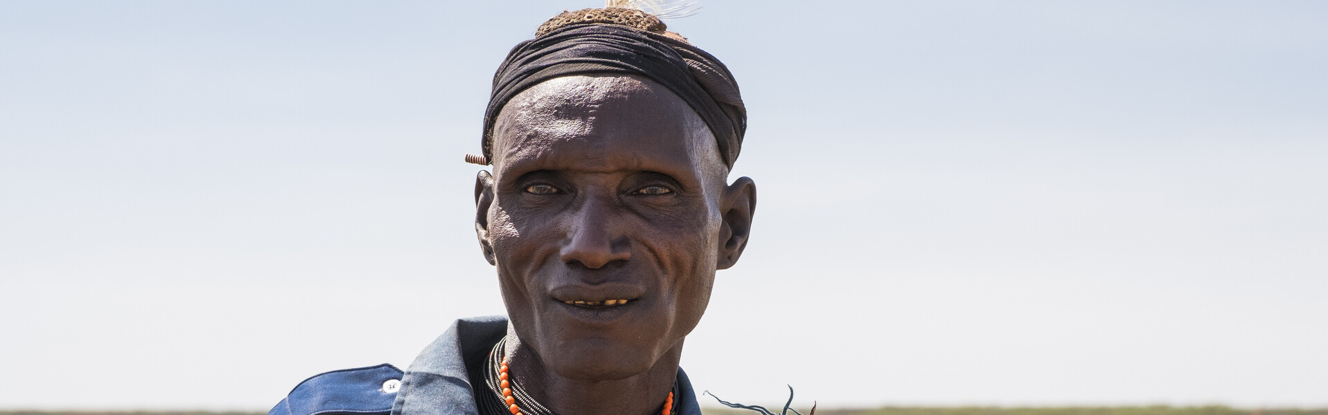 Ein Hirte aus Kenia steht vor seiner Herde.