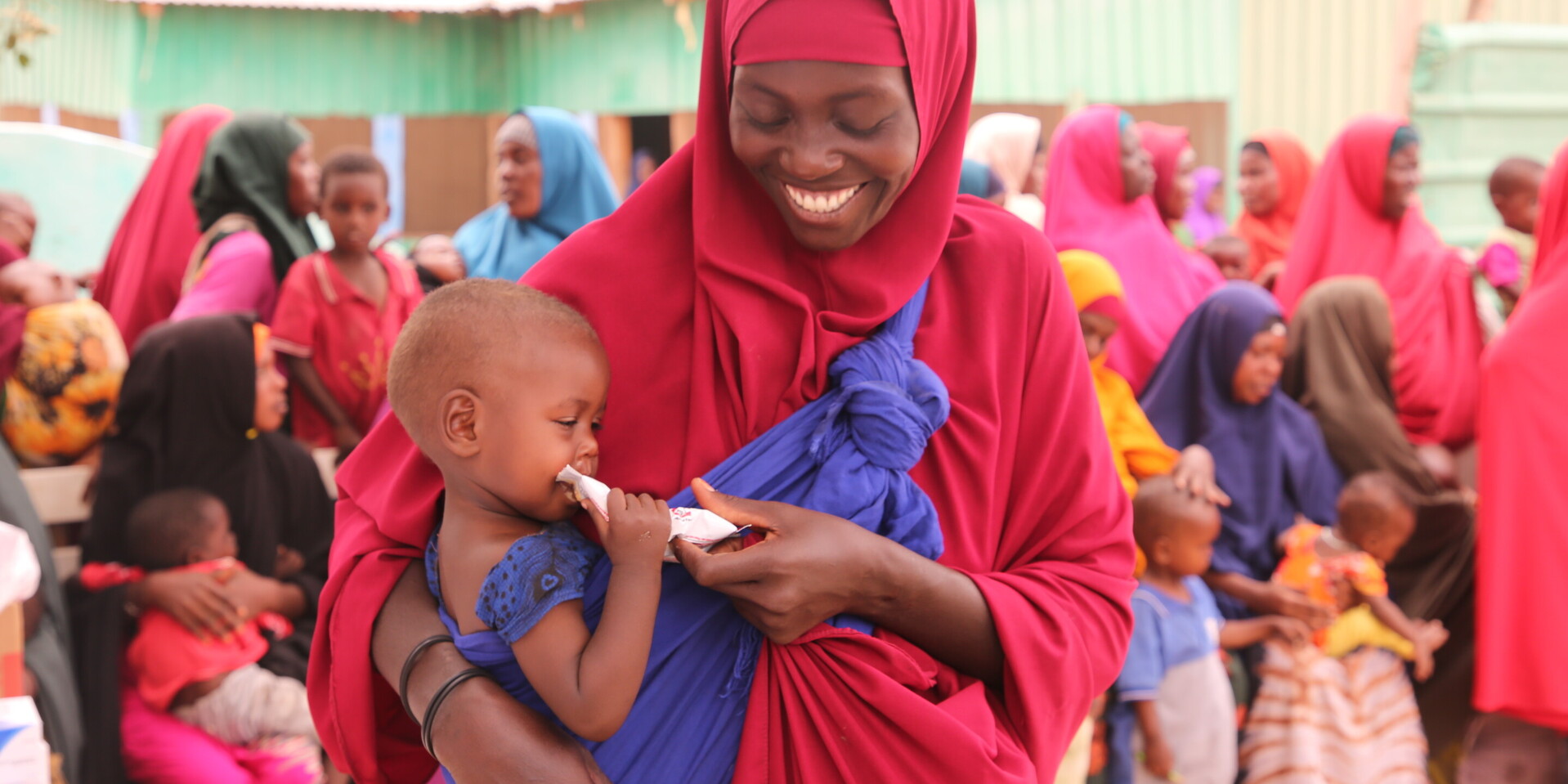 Frau mit Kind, das Notfallnahrung gegen Hunger erhalten hat, in Somalia