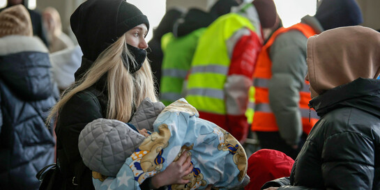 Eine vor dem Krieg in der Ukraine geflüchtete Frau hält ihr Kind in den Armen