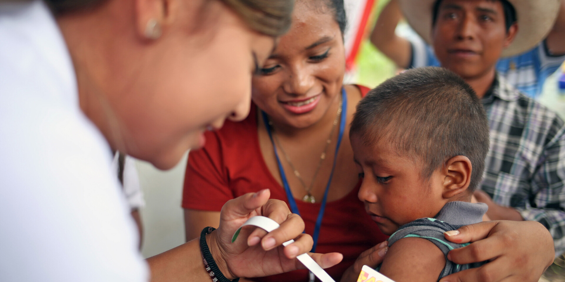 Eine Helferin in Guatemala untersucht ein Kind auf Unterernährung Eine Helferin in Guatemala untersucht ein Kind auf Unterernährung