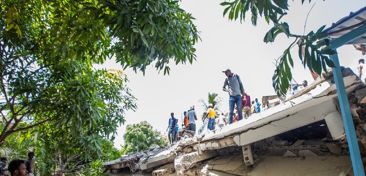 Menschen auf einem zerstörten Gebäude nach dem Erdbeben in Haiti 2021