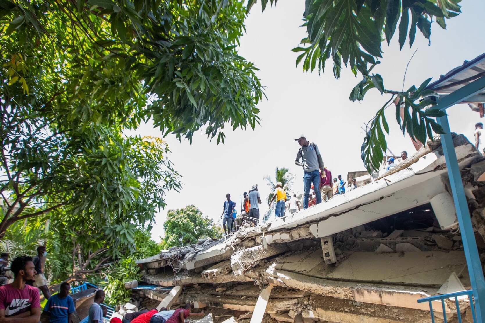 Menschen auf einem zerstörten Gebäude nach dem Erdbeben in Haiti 2021