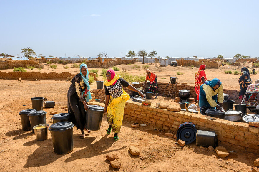 Frauen transportieren große Behälter mit Trinkwasser im Sudan