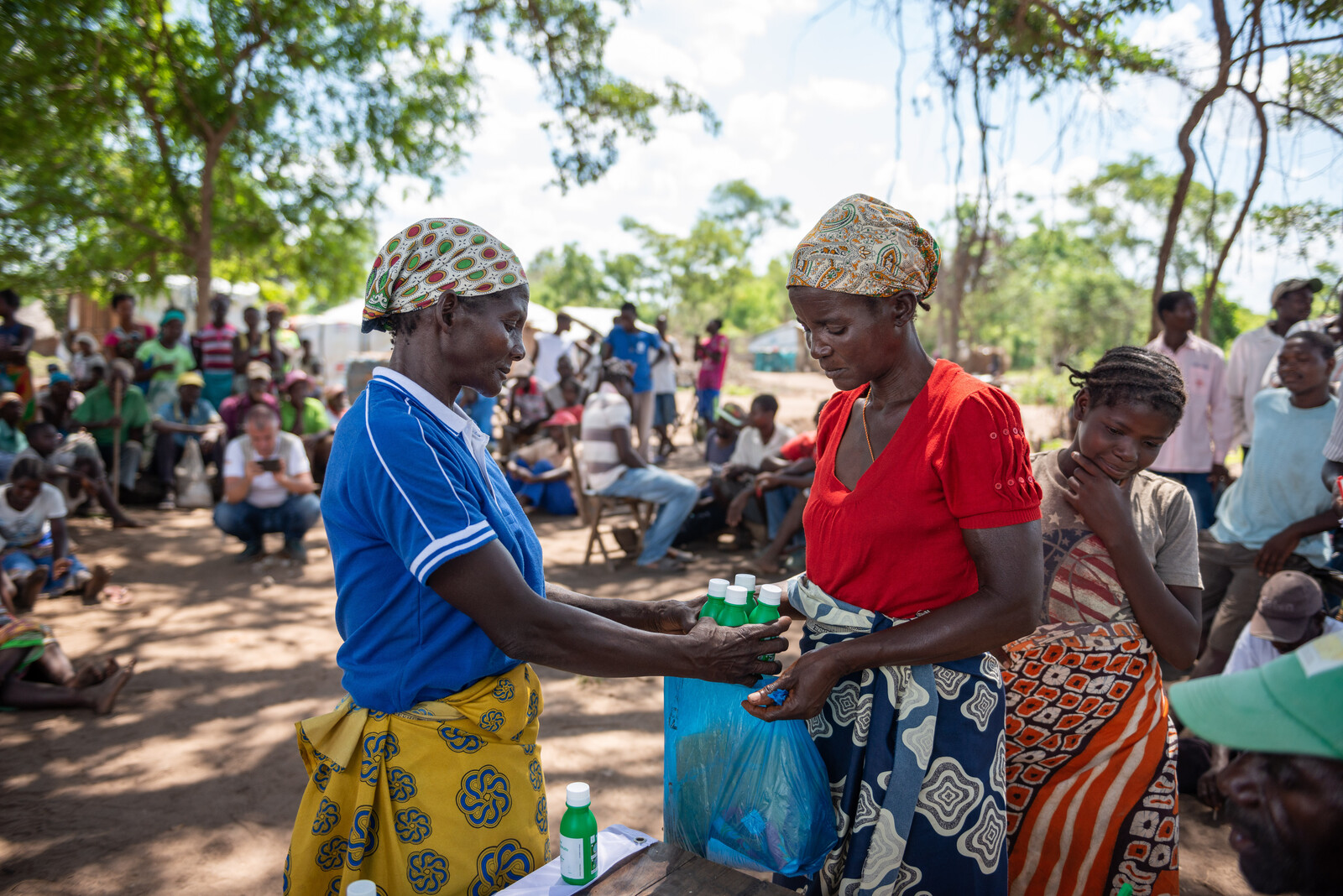 Helferinnen in Mosambik verteilen Chlorfläschchen, um das verunreinigte Wasser nach dem Zyklon Idai in Mosambik von Keimen zu befreien