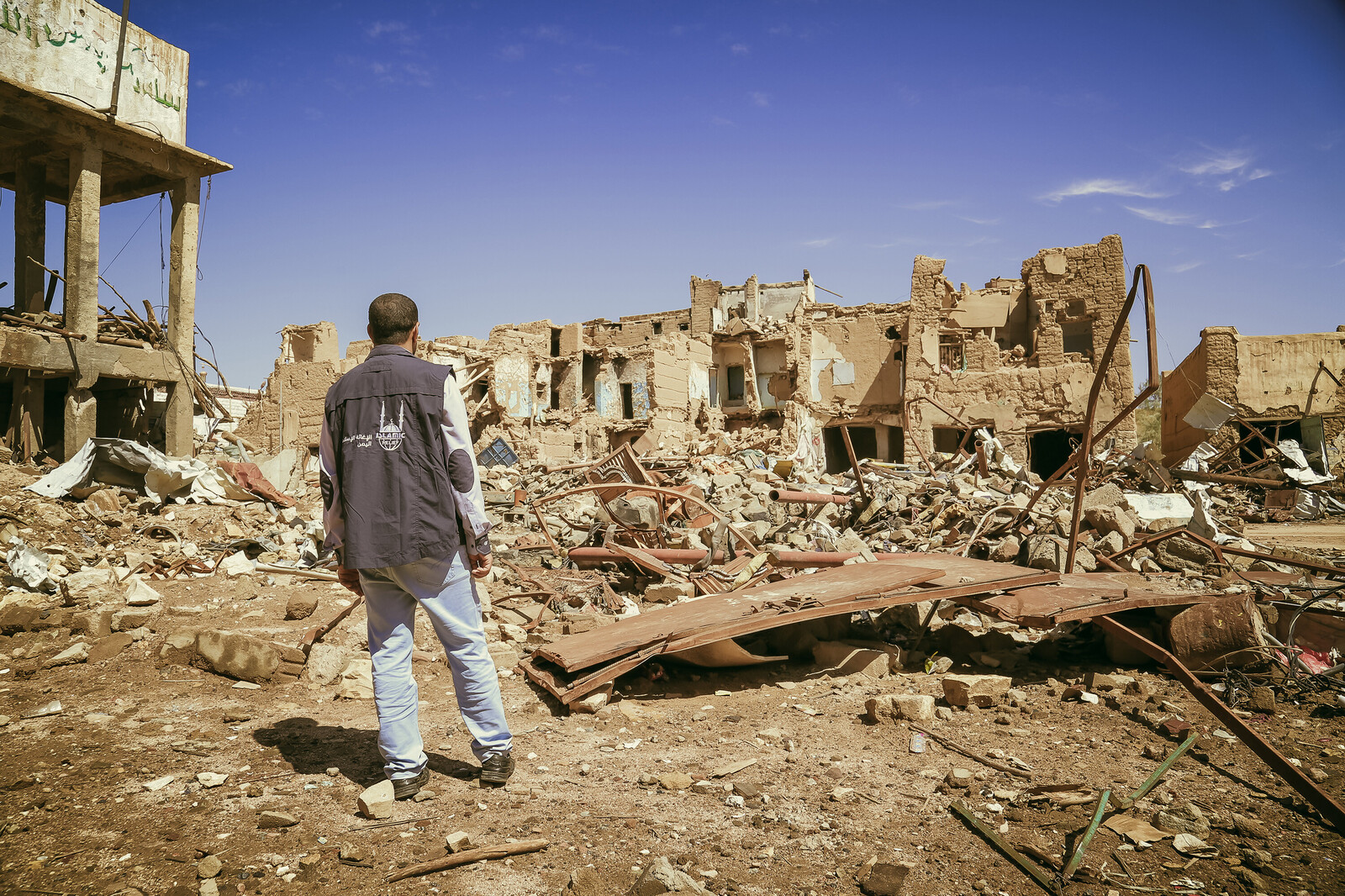 Ein Mitarbeiter schaut auf die Ruinen, die ein Bombenangriff hinterließ. Der Konflikt im Jemen tobt schon seit fast zwei Jahren.