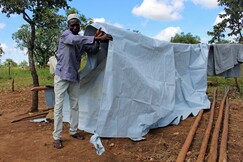 Ein Mann errichtet seine erste Unterkunft, nachdem er aus dem Südsudan geflohen ist Ein Mann errichtet seine erste Unterkunft, nachdem er aus dem Südsudan geflohen ist