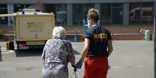 Eine Helferin unterstützt eine Frau beim Hochwasser Deutschland