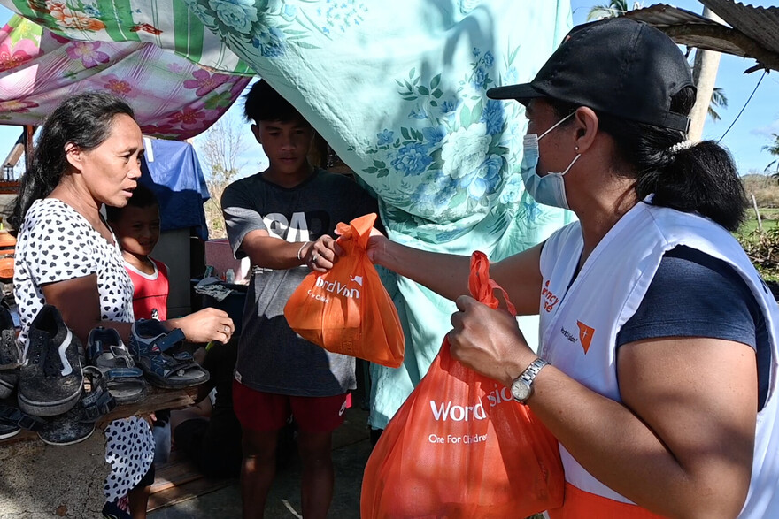Nach einem Taifun auf den Philippinen verteilt eine Helferin Hilfspakete von der Organisation World Vision Nach einem Taifun auf den Philippinen verteilt eine Helferin Hilfspakete von der Organisation World Vision