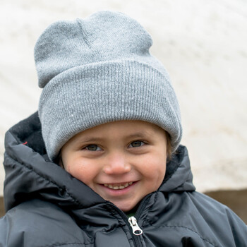 Ein Kind mit Winterjacke und Mütze