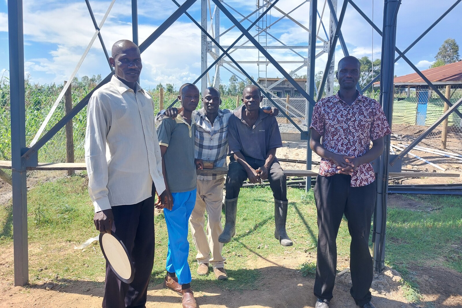 Vier Männer stehen in West-Kenia vor einem neues Wasser-Bohrturm