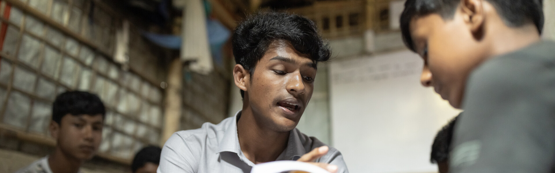 Ein Mann liest einem Jungen aus einer Broschüre vor. 